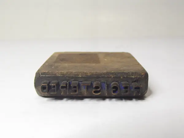 Sello de metal con base de madera
